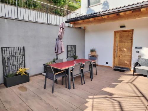 a patio with a red table and chairs at MOUNTAIN DELUXE 27 APARTMENTS con WELLNESS in Cavalese