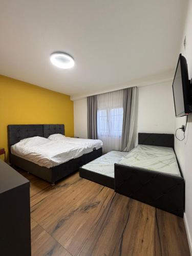 a room with two beds and a television in it at Home City Center - 3BedR & 3BathR - Free Private Parking in Prishtinë