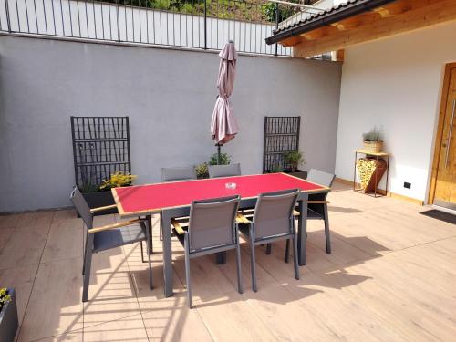 a red table and chairs in a patio at MOUNTAIN DELUXE 27 APARTMENTS con WELLNESS in Cavalese