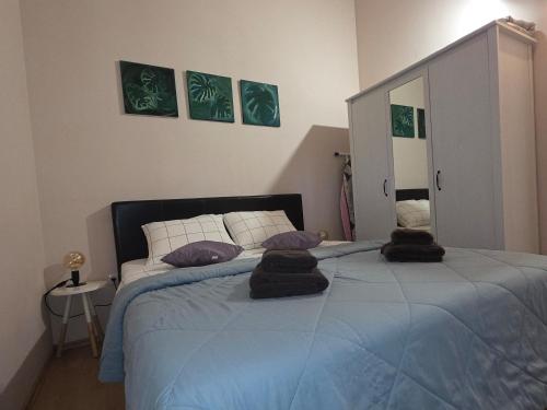 a bedroom with a blue bed with pillows on it at Apartment Dulcis Domus in Bale