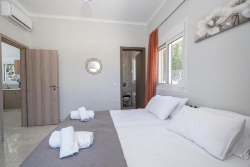 a white bedroom with a large bed with white pillows at Studios Maximo in Karavádhos