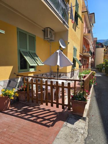 a fence with an umbrella in front of a building at La Casa di Nonna Mari in Moneglia