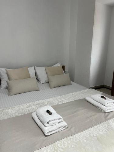 a white bed with two towels on top of it at Hotel Palace Struga in Struga