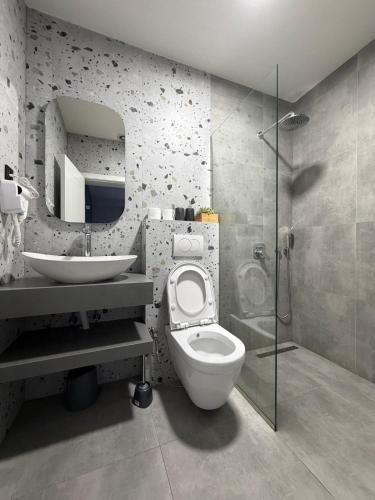 a bathroom with a toilet and a sink and a shower at Home City Center - 3BedR & 3BathR - Free Private Parking in Prishtinë
