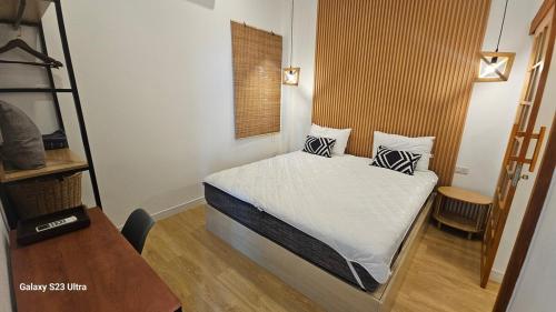 a small bedroom with a bed with white sheets and pillows at Beas Boutique House Khlong Dow in Ko Lanta