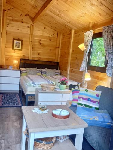 a room with two beds and a table in a cabin at Letniak pod Dębami in Grabina