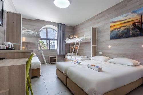 two beds in a room with two bunk beds at HI - Karei Deshe Hostel in Khirbet Minim