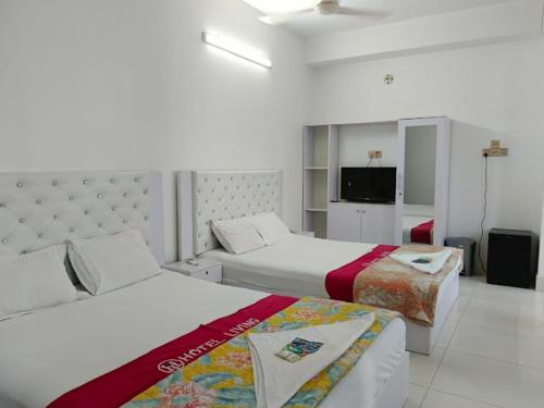 a hotel room with two beds and a flat screen tv at Dhaka Residence Hotel in Dhaka