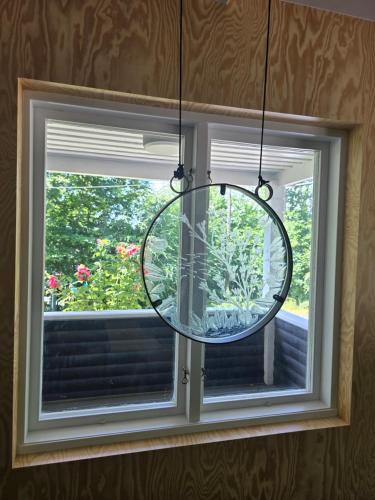a mirror hanging in front of a window at Malenasro in Karlshamn