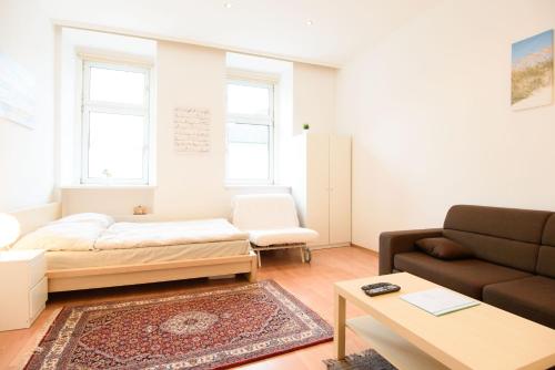 - un salon avec un lit et un canapé dans l'établissement Vienna Living Apartments - Dampfgasse, à Vienne