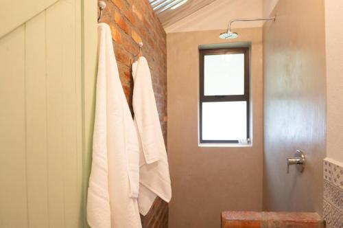 a bathroom with white towels hanging on a wall at The Olive Room in Kampersrus AH