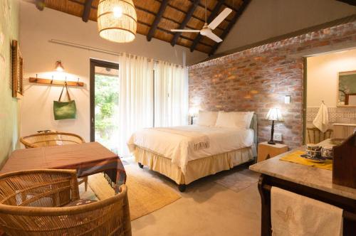 a bedroom with a bed and a brick wall at The Olive Room in Kampersrus AH