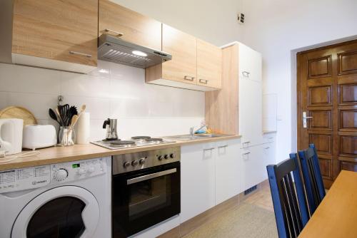 y cocina con lavadora y fogones. horno superior en Vienna Living Apartments - Dampfgasse, en Viena