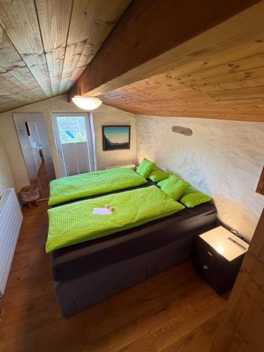 a bedroom with a bed with green sheets on it at Rustico senza punti in Contra