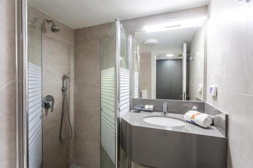 a bathroom with a sink and a shower at HI - Karei Deshe Hostel in Khirbet Minim
