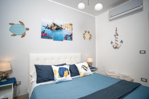 a bedroom with a blue bed with two pictures on the wall at Brisa Home Beach in Mazzeo