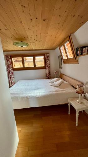 a large bed in a room with a wooden ceiling at Rosenhüsli in Gerzensee