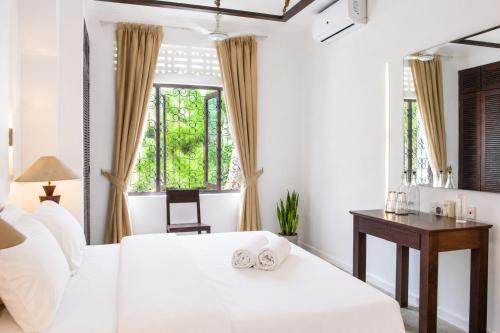 a bedroom with a bed and a desk and a window at Rodrigo House in Colombo