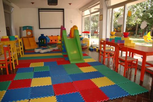 a room with a table and chairs and a play area at Villaggio Los Nidos in Lignano Sabbiadoro