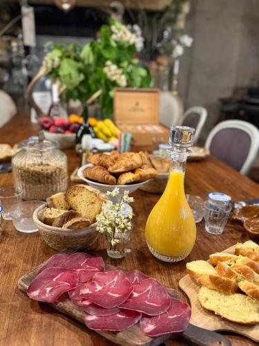 a table with food and bread and a bottle of orange juice at L Annexe d Aubrac in Aubrac