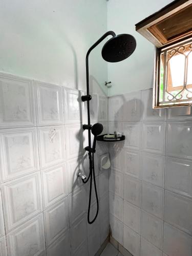 a shower in a bathroom with white walls at Happy homes stay in Namugongo