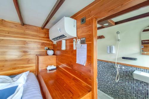 a small room with a bed and a sink at Private Trip Labuan Bajo 2D1N in Labuan Bajo