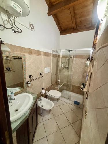 a bathroom with a toilet and a sink and a shower at casetta sul porticciolo in Stintino