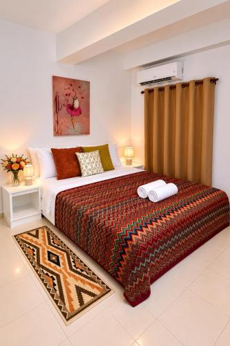 a bedroom with a king sized bed with a rug at Holiday House Kata & Karon Phuket Hotel in Kata Beach