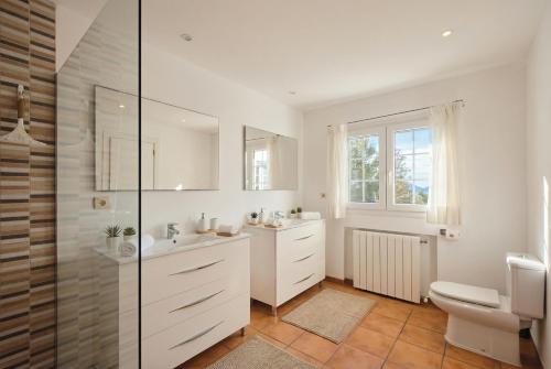 a white bathroom with a sink and a toilet at Can Paredes Ibiza in Ibiza Town