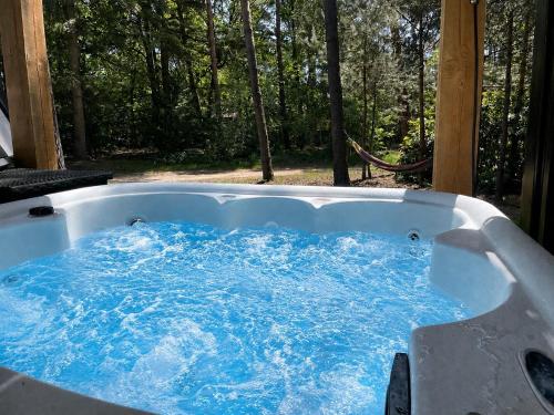 a jacuzzi tub with blue water in it at Skydeck Cabin met Jacuzzi & Rooftop in Holten