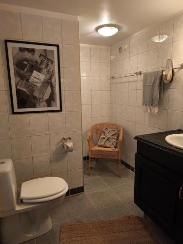 a bathroom with a toilet and a sink and a chair at Skärvsta gamla skola in Sollefteå