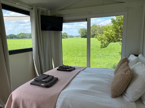 a bedroom with a bed and a large window at benbmeestervankampen in Oosterwolde