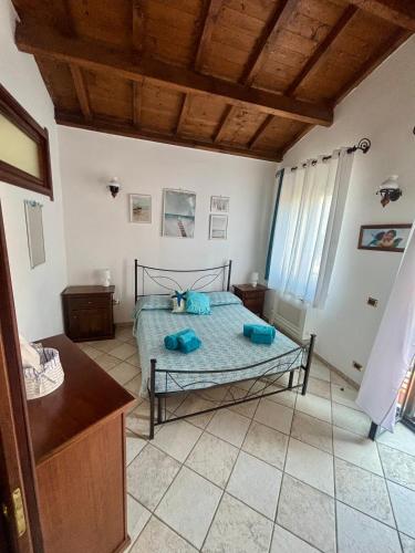 a bedroom with a bed with blue pillows on it at casetta sul porticciolo in Stintino