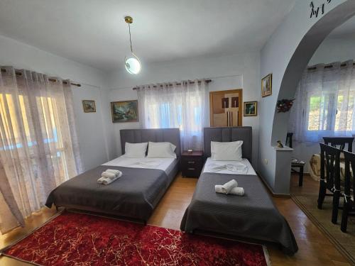 two beds sitting in a room with windows at Petrit apartament in Qeparo