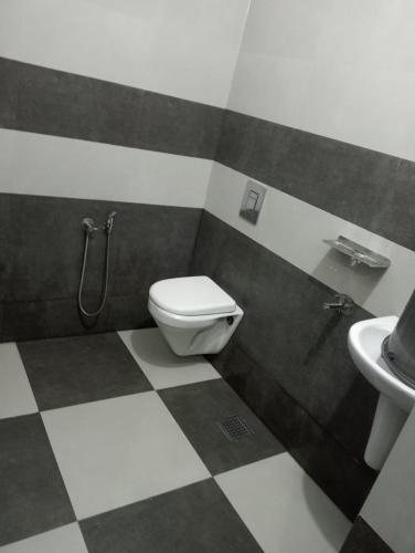 a bathroom with a toilet and a sink at Zero One Residency in Quilāndi