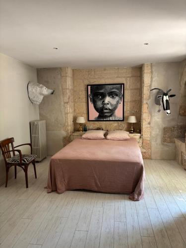 a bedroom with a bed and a portrait of a boy at Le Bon Appart in Angoulême