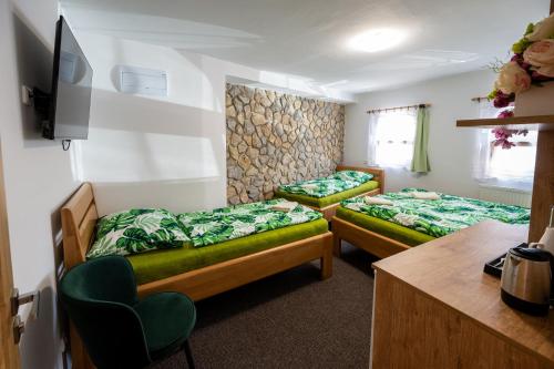 a room with two beds and a tv in it at Vinný sklep u Křížů in Milotice