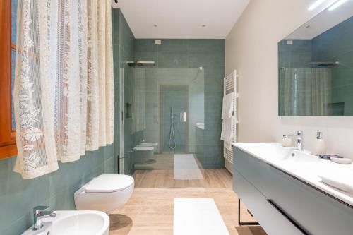a bathroom with two sinks and a toilet and a shower at 108 B&B Valdobbiadene in Bigolino