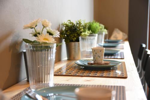 een tafel met borden en vazen met bloemen erop bij Terrazza Santa Chiara in Catania