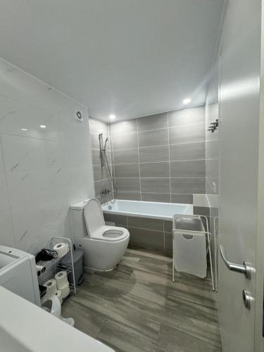 a bathroom with a tub and a toilet and a sink at Olimp sea view in Olimp