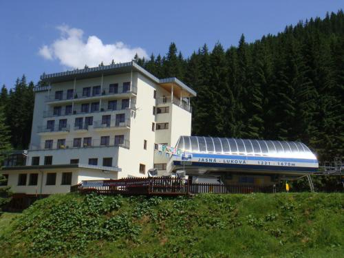 a building with a train parked in front of it at Hotel FIS Jasná in Demanovska Dolina