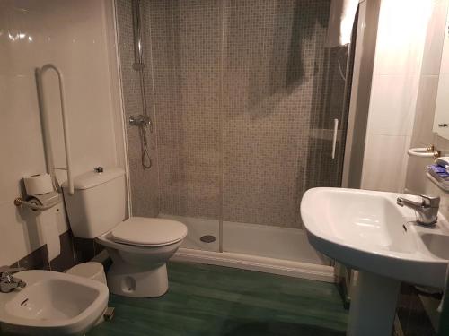 a bathroom with a toilet and a sink and a shower at Hotel Cardinal in Albacete