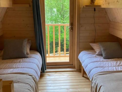 two beds sitting in a room with a window at Cabane spacieuse - 7 pers. - API-1-52-2440 in Meyrueis