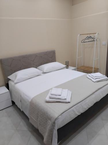 a bedroom with a large bed with towels on it at Papale AIRPORT HOUSE in CTA