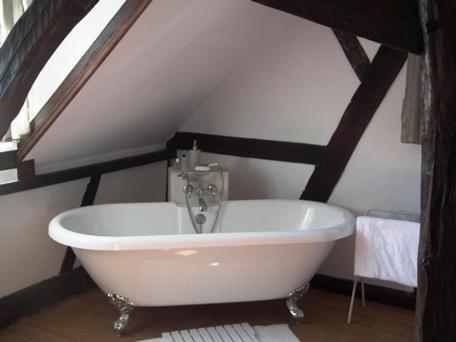 bañera blanca en una habitación con ático en L'Escapade de Marijac, en Lyons-la-Forêt