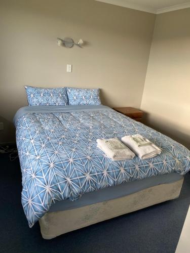 a bedroom with a bed with two towels on it at South Catlins Cottage in Tokanui
