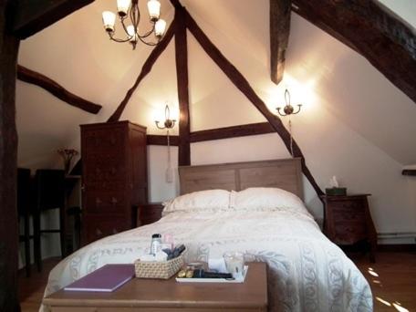 1 dormitorio con 1 cama grande y cabecero de madera en L'Escapade de Marijac, en Lyons-la-Forêt