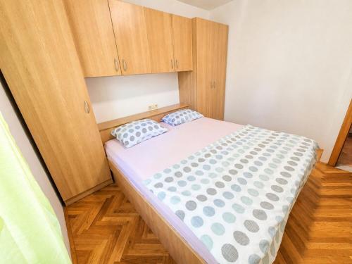 a small bedroom with a bed and wooden cabinets at Ribarićevi dvori in Banjol
