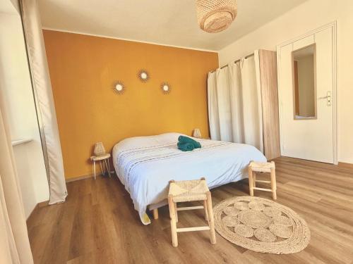 a bedroom with a bed and two stools in it at L'échappée Belle "15 min Europa Park" in Rhinau