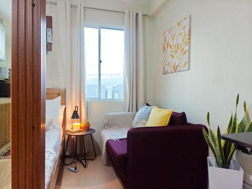 a living room with a couch and a window at WanderDesk Living-Studio Unit with Workstation in Piapi